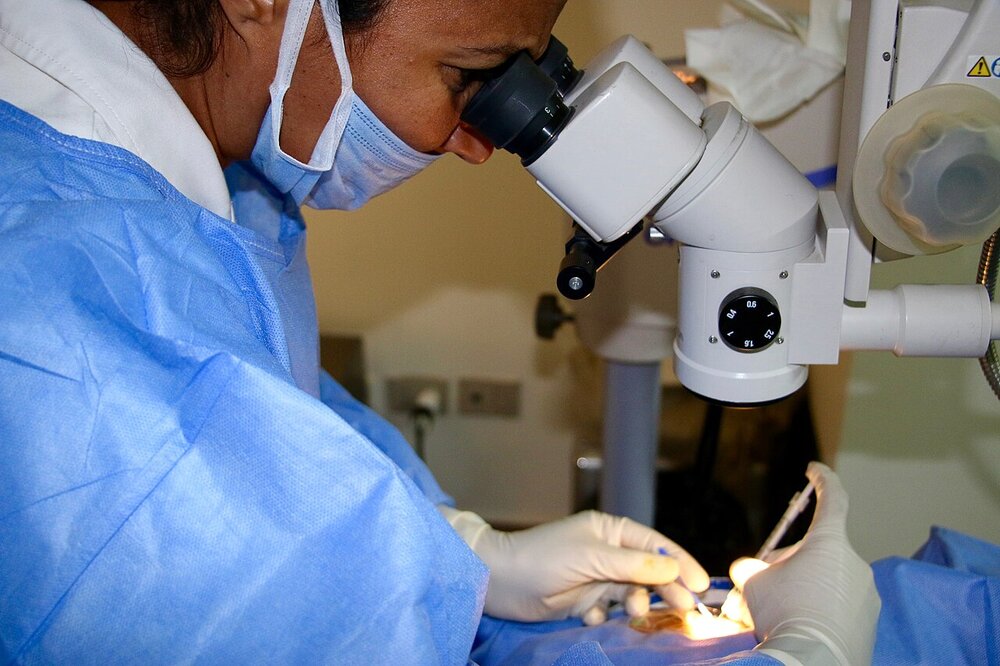 Ophthalmologist giving an intravitreal injection under the operating microscope